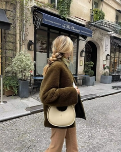Chic cream hobo bag with pebble leather and metal chain detail on model in sherpa coat