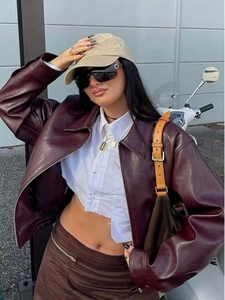 Giacca chic in pelle bordeaux abbinata a camicia crop bianca e minigonna marrone