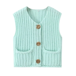Detail of mint green knit vest featuring textured V-neck and decorative gold buttons