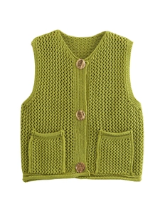 Detail of green crochet vest featuring chunky knit texture and vintage gold buttons