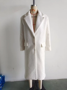 Detailed close-up of white long faux fur coat featuring soft texture and classic lapels