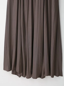 Vue détaillée de la robe plissée en satin marron foncé avec plis accordéon