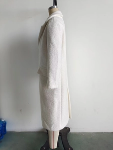 Close-up of white soft textured long coat showing high-quality wool-like bouclé fabric detail