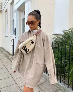 Close-up of oatmeal tweed oversized coat with large pockets and plush crossbody bag details