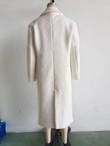 Macro detail of creamy white wool coat back showing the high-quality textured fabric and vent