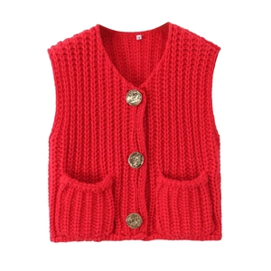 Detail of red cable knit vest featuring gold metallic buttons and V-neckline texture