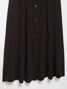 Detail of dark brown knit dress featuring a vertical placket with three vintage gold buttons