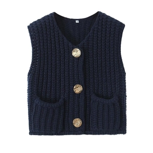 Detail of navy knit vest showing golden embossed buttons and symmetrical front pockets