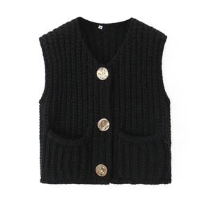 Detail of black knit vest featuring V-neckline and decorative gold embossed buttons