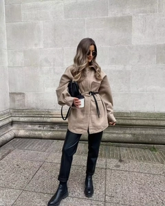 Street style shot of oversized khaki shacket with large pockets and stylish black belt
