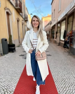 White long faux fur coat styled with striped sweater and wide-leg jeans in street view