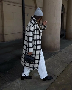 Close-up of black and white checkered teddy coat texture with luxury leather handbag
