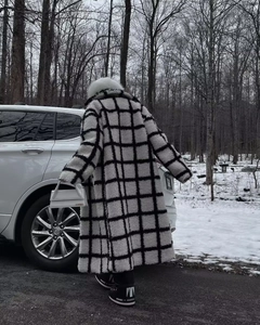Macro detail of plush black and white checkered long coat featuring a thick faux fur collar