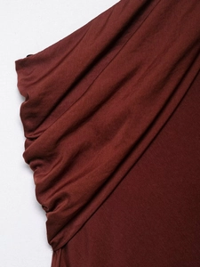 Vue détaillée du tissu plissé rouge foncé et de la texture drapée de la robe midi