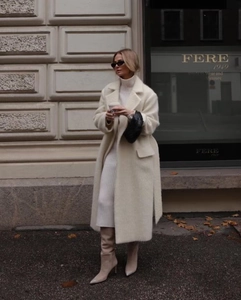Detailed view of women's long beige wool coat with a soft velvety texture and elegant silhouette