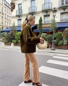 Outdoor street style view of dark olive faux fur coat with corduroy flared trousers