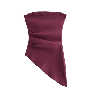 Detail of burgundy tube top featuring side pleats and asymmetric hemline cut