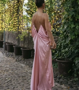 Close-up of pink satin maxi dress featuring an elegant backless design and draped details