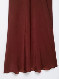 Détail de la robe midi en satin bordeaux montrant le tissu brillant et l'ourlet
