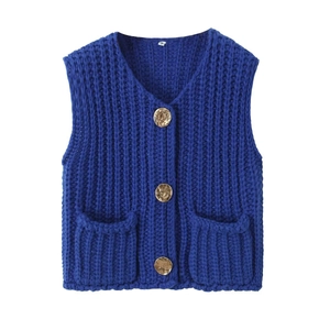 Macro detail of navy chunky knit vest showing texture, gold buttons, and pockets