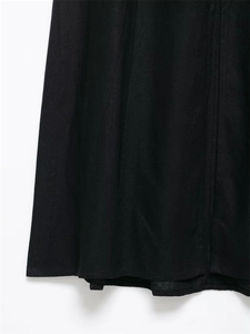 Detail shot of black linen midi dress showing tight weave texture and precise vertical seams