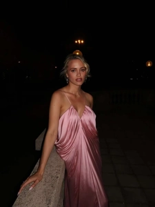 Detail of pink satin maxi dress showing v-neckline and elegant silky fabric draping
