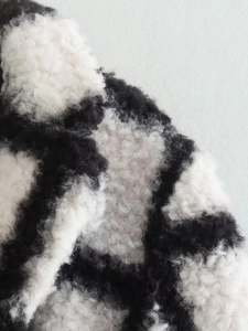 Close-up of thick black and white cow print plush faux fur fabric texture