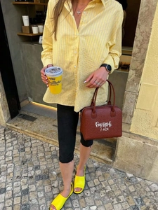 Dettaglio di una borsa Boston in pelle marrone con stampa artistica calligrafica bianca