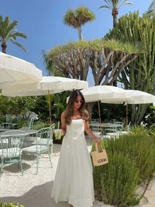 Détail d'une robe midi blanche à bord contrasté avec silhouette fluide en ligne A