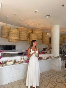Détail de la robe midi blanche élégante avec bordure noire dans un décor de café méditerranéen