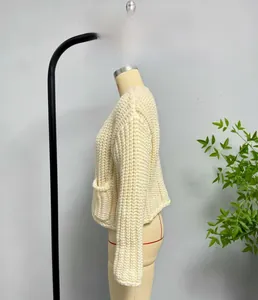 Close-up of beige chunky knit cardigan showing thick yarn texture and side pocket detail