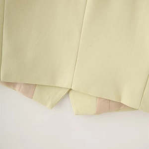 Detailed macro view of asymmetric vest hem in light yellow linen fabric and lining