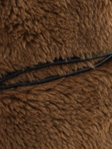 Macro shot of fluffy brown faux fur texture with high-quality black leather piping detail