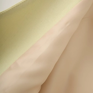 Detailed close-up of light green linen fabric with smooth pink inner lining texture