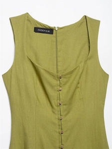 Detail of olive green linen dress featuring U-neckline and front brown button closure