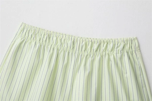 Detailed close-up of elastic waistband on light green striped poplin cotton shorts