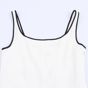 Détail de la robe blanche sans manches avec bordure noire contrastée et fermeture invisible
