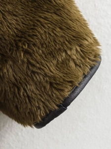 Close-up of olive brown faux fur sleeve with high-quality black faux leather trim edge
