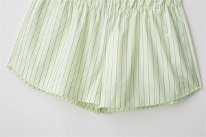 Detail of light green striped poplin shorts with elastic waistband and soft cotton texture