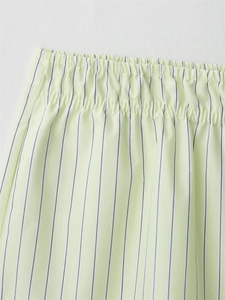 Close-up of elastic waistband on light green striped poplin shorts with fine stitching