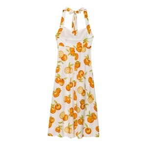 Detail of white halter midi dress with orange print and back bow tie decoration