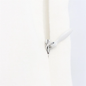 Détail de la robe midi blanche avec fermeture éclair invisible et texture de tissu lisse