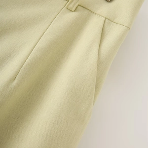 Detailed macro shot of pistachio green linen vest set featuring pocket and waist loops