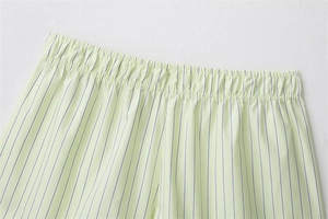 Detailed view of elastic waistband on light green striped poplin shorts with stitching