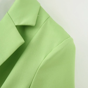 Detail of apple green blazer with notched lapel and fine twill texture stitching
