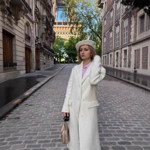 Elegant long off-white tweed coat for women with classic lapels and flap pockets