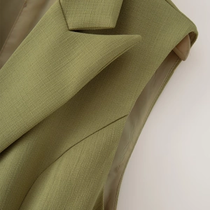 Détail du gilet vert olive montrant le revers cranté et la doublure intérieure premium
