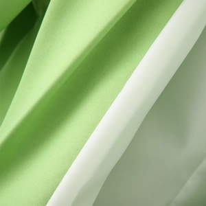 Detailed macro view of the light green twill fabric texture and soft white inner lining