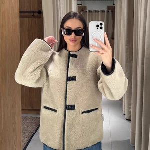Short cream shearling jacket with black faux leather trim and toggle closures