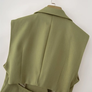 Vue détaillée de la veste vert menthe montrant la texture du tissu et le dos nu